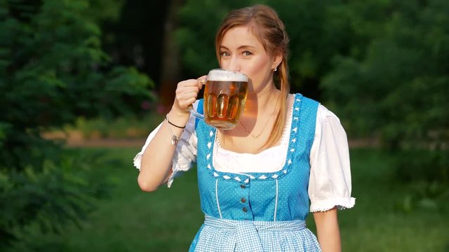 Young woman in blue bavarian dirndl celebrating