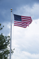 American flag also called the Stars and Stripes or Old Glory flying at full mast on flag pole in United States
