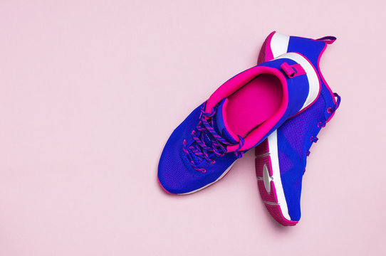 Ultra blue violet pink female sneakers on pastel pink background flat lay top view with copy space. Sports shoes, fitness, concept of healthy lifestile, everyday training.