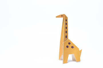 A yellow origami giraffe stands tall on a white background