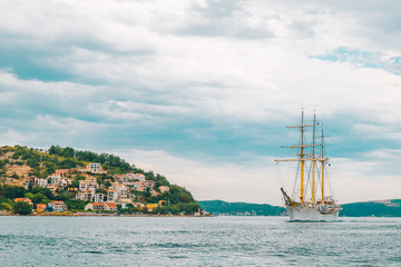 sail ship at sea with beautiful view of mountains on background