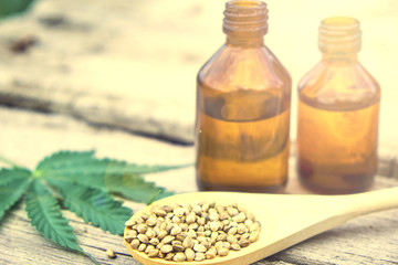 hemp leaves on wooden background, seeds, cannabis oil extracts jars