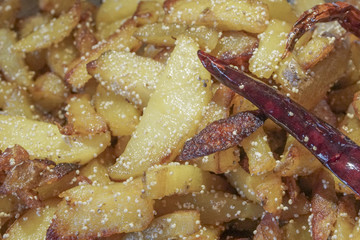 Fried potato pieces with fried red chilly