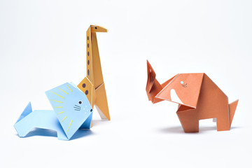 Paper origami giraffe, lion and elephant on white background