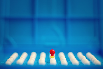 Unique red pin among many white ones. Stand out of crowd, individuality, difference and leadership...