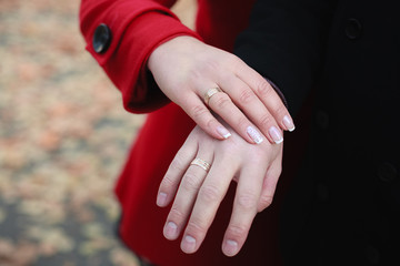 hands of groom and bride in autumn