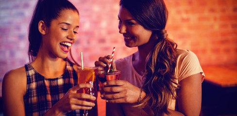 Two young women having cocktail drinks