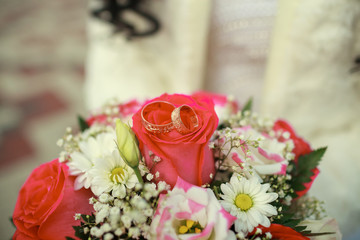 Gold wedding rings on a bouquet of roses