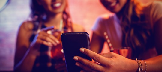 Two young women using mobile phone