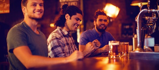 Group of male friends watching football match