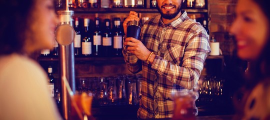 Bartender mixing a cocktail drink in cocktail shaker