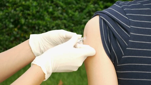 4k video of Doctor injecting flu vaccine to patient's arm