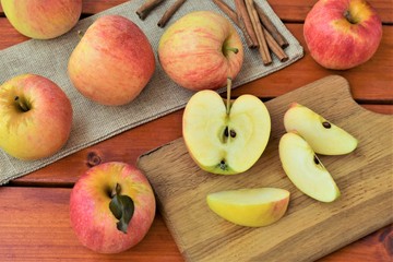 Naklejka na ściany i meble Ripe apples chopped on a wooden board, autumn harvest concept.