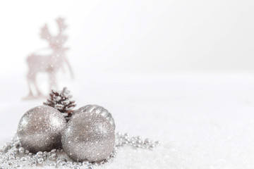 Christmas balls and fir branches with a reindeer against a white background