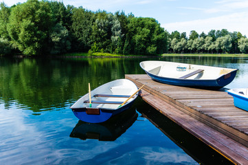 Obraz premium Cityscape of empty boat are parked by a lake shore in park in megapolis