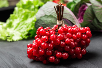 Bunches of red berries, red currant or rowanberry in the first plan. Cabbage, kale and lettuce on the second plan