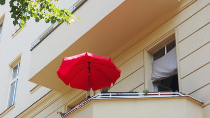 Obraz premium Berlin-Mitte: Lato na balkonie, czerwony parasol