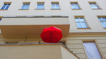 Sommer auf dem Balkon: Roter Sonnenschirm