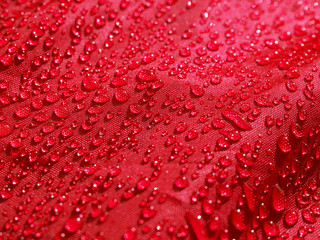 Red waterproof fabric with waterdrops close up