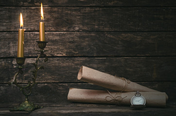 Wrapped scroll paper pages in the light of burning candle. The old letter. Writer or author concept.