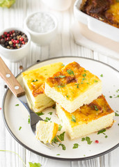Fluffy omelet baked with zucchini, kids healthy Breakfast, delicious casserole. On white wooden background