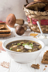 Forest mushroom soup with boletus, potatoes, pearl barley and sour cream. Classic Russian cuisine, delicious healthy vegetarian lunch. Autumn food