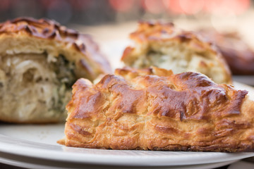 Close-up: Appetizing pieces of delicious baked pie are on a white big plate.