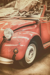 Fototapeta premium Vintage weathered classic red car in an old garage