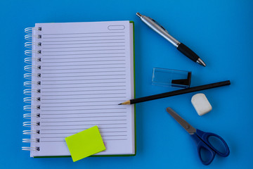 School and office supplies on a blue background. Learning materials. Top view.