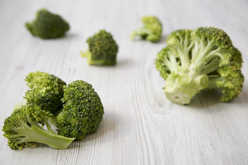 Raw broccoli on white wooden background, side view. Selective focus.