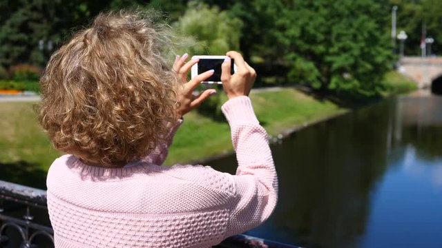 Woman Taking Photo On Smartphone In The Park