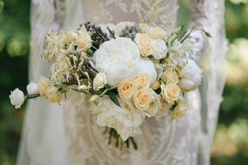 Beautiful wedding bouquet for the bride with peonies and white roses and eustoma