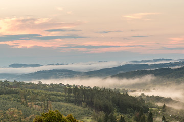 Early morning photography near the town Zlin, Czech Republic during a morning colorful sunrise and a mist/fog in the valley. Trees made leading lines throughout the photo.