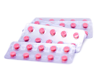Pink pills in a package isolated on a white background
