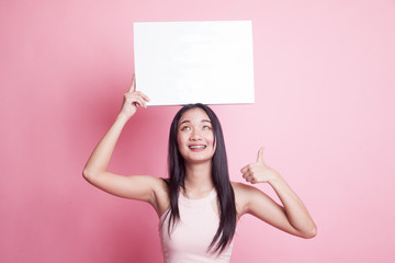 Young Asian woman show thumbs up with white blank sign.