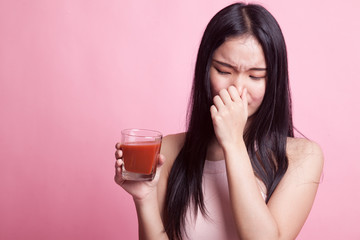 Young Asian woman hate tomato juice.