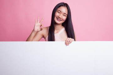 Young Asian woman show OK with blank sign.