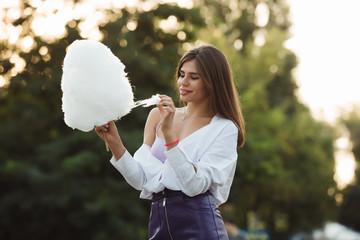 Happy woman holding big cotton candy in a park