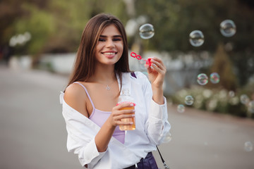 Happy girl blowing soap bubbles