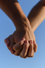 two male hands against the sky