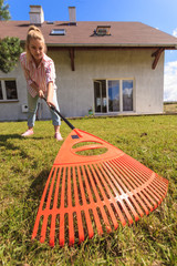 Unusual angle of woman raking leaves