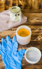 jar of sugar paste for sugaring, blue gloves,  towels are on wood background (vertically)
