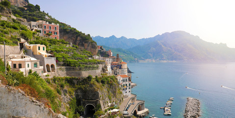 Stunning sunny day view of Atrani village overhanging the sea with green vineyards, Amalfi Coast,...