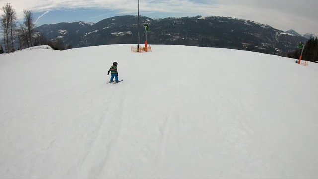 Little boy skiing.
A 5 year old child enjoys a winter holiday in the Alpine resort. Stabilized footage. Slow motion.
