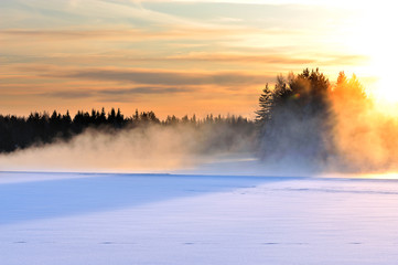 Obraz na płótnie Canvas Mist over freezing river on a cold winter day. Winter landscape in Finland.