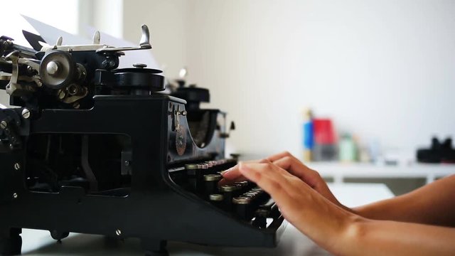 Close up of writer typing on retro typewriter