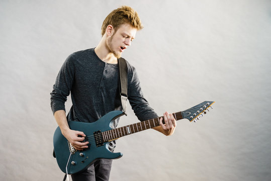 Young man playing electric guitar