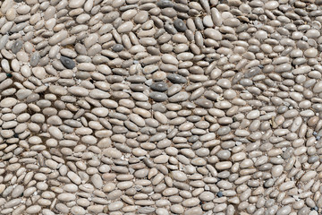 Texture and background with small pebbles. Sidewalk on a street in Rhodes. Greece