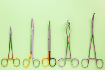 Medical equipments including surgical instruments on a green background. top view, copy spase