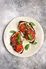 Rye toasts with soft cheese, tomato, red onion and capers.Top view.